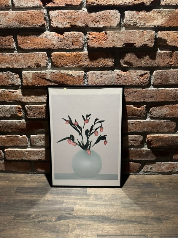 When the Flower Bows, framed against brick